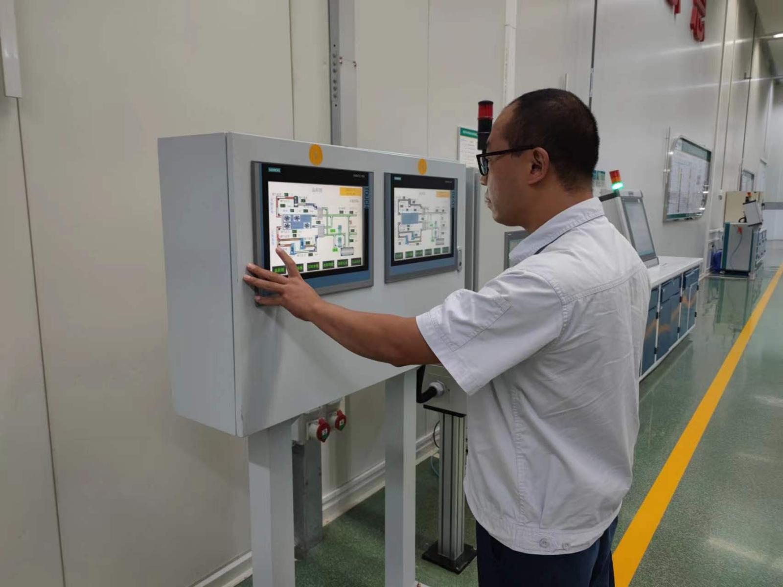 圖為該車間創(chuàng)新工作組人員在現(xiàn)場調試控制系統(tǒng)