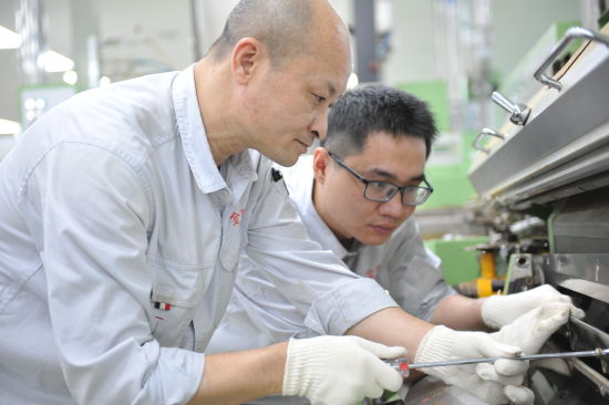 圖為工作室成員解決設(shè)備故障.