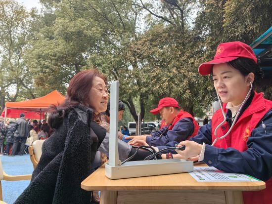 圖為志愿者為社區(qū)居民測(cè)量血壓