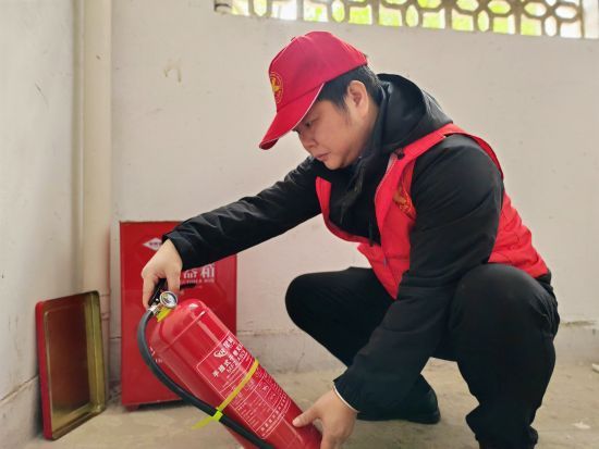 圖為志愿者協(xié)助社區(qū)檢查消防設(shè)施