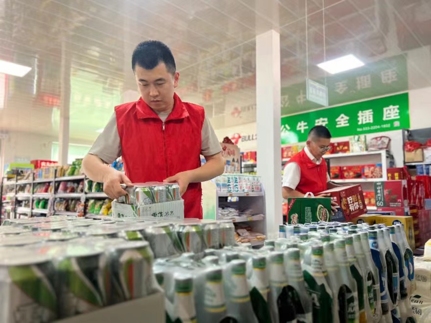 圖為桓臺(tái)煙草工作人員幫助金福源商店整理商品