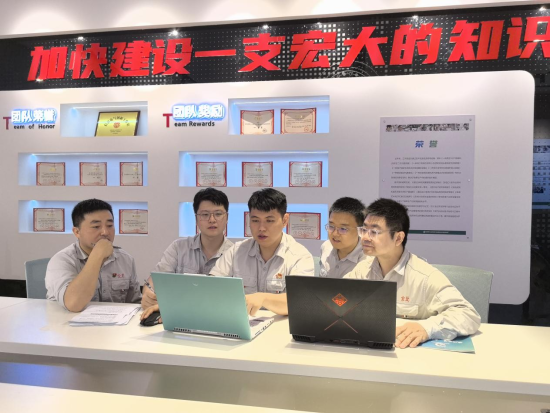 圖為小組成員集中討論方案難點(diǎn)