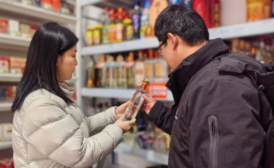 圖為新建區(qū)煙草工作人員指導(dǎo)丁雄劍進(jìn)行商品陳列分類