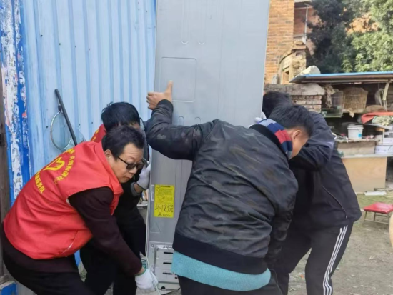 圖為志愿者為零售戶搬運(yùn)店面改造貨物