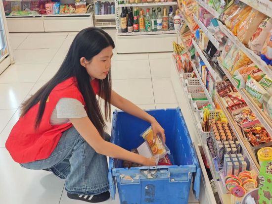 圖為志愿服務(wù)者幫忙陳列貨架 圖為志愿服務(wù)者幫忙陳列貨架