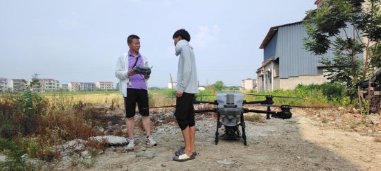 圖為熊冰云與專業(yè)人員一起開展無人機(jī)噴灑農(nóng)藥 圖為熊冰云與專業(yè)人員一起開展無人機(jī)噴灑農(nóng)藥