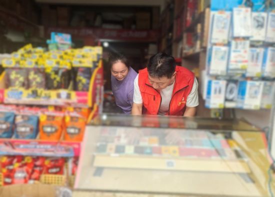 圖為黨員志愿者幫助整理柜臺.jpg 圖為黨員志愿者幫助整理柜臺.jpg