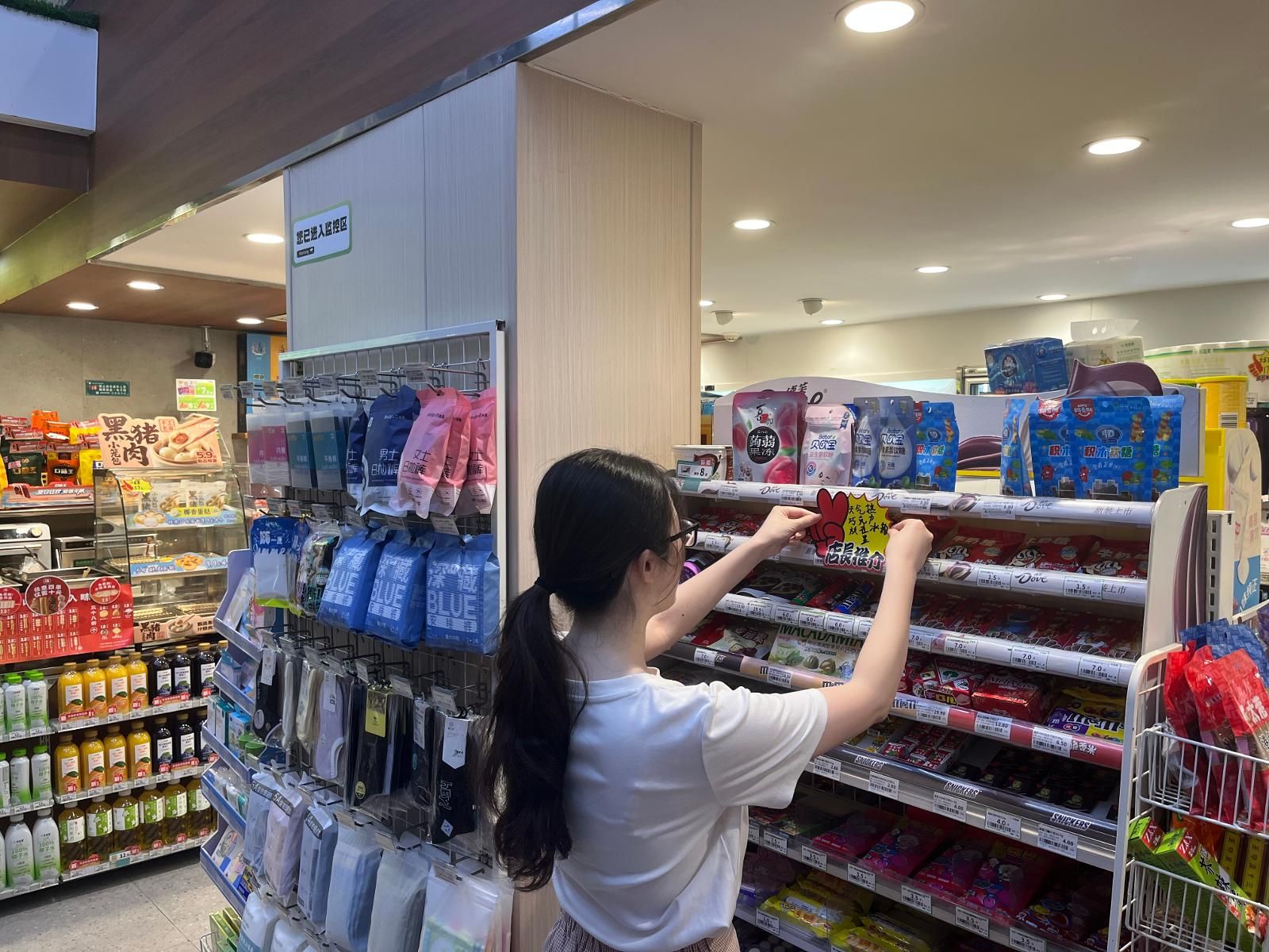 營銷人員幫客戶張貼商品標識.jpg 營銷人員幫客戶張貼商品標識.jpg